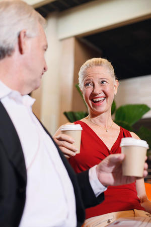 Businessman and businesswoman enjoying coffee in airport loungeの写真素材