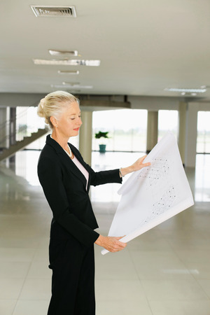 Businesswoman looking at blueprintの写真素材