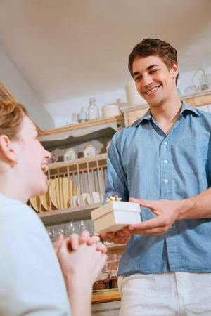 Man giving woman a surprise giftの写真素材