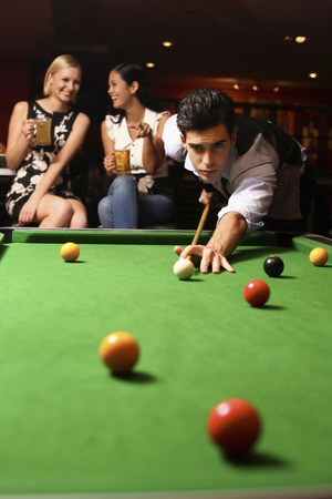 Man playing pool, women watchingの写真素材
