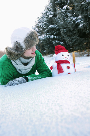 Man looking at snowmanの写真素材
