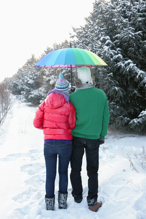 Man and woman sharing an umbrellaの写真素材