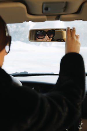 Businesswoman adjusting car's rear view mirrorの写真素材