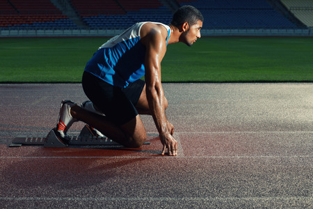 Male athlete crouching on starting line