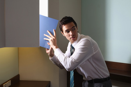 Businessman stealing document from cabinetの写真素材