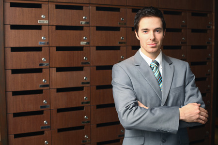 Businessman standing in front of the mailbox