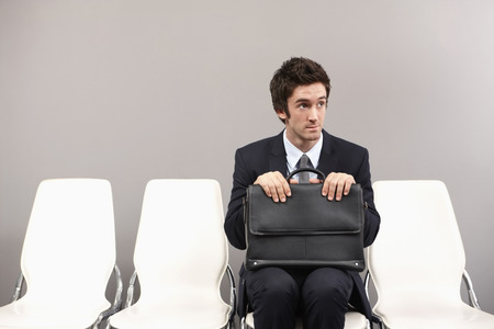 Businessman sitting on chair, waitingの写真素材