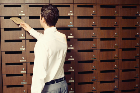Businessman putting letter into mailboxの写真素材