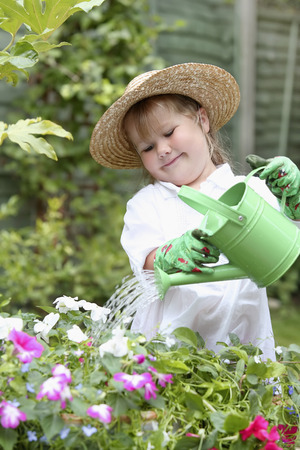 Girl watering plants in gardenの写真素材