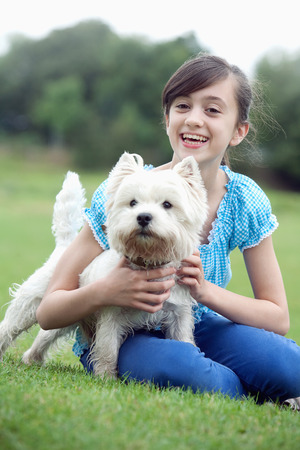 Girl holding pet dogの写真素材