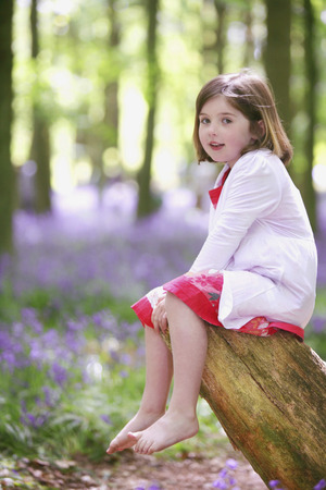 Girl sitting on tree trunkの写真素材