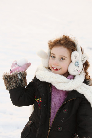 Girl holding a snowballの写真素材