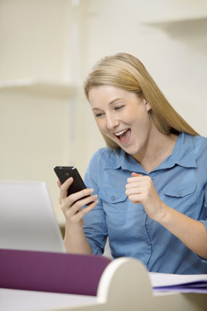 Businesswoman reading text message on smart phoneの写真素材