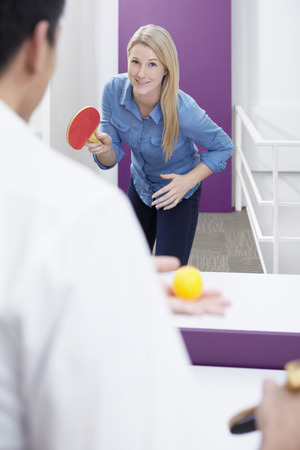 Businessman and businesswoman playing table tennisの写真素材