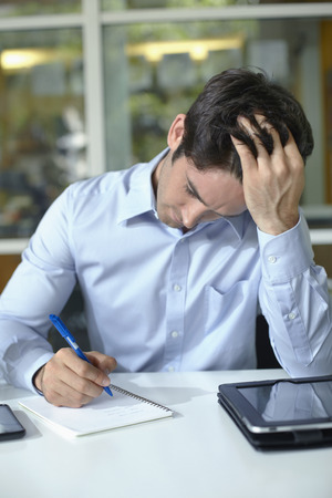 Businessman concentrating while writingの写真素材