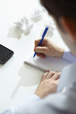 Businessman writing in notebookの写真素材