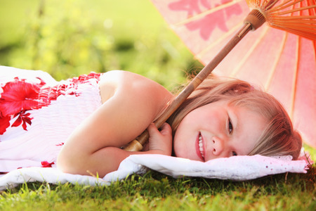 Girl lying under an umbrellaの写真素材