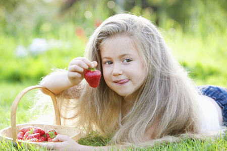 Girl holding a strawberryの写真素材
