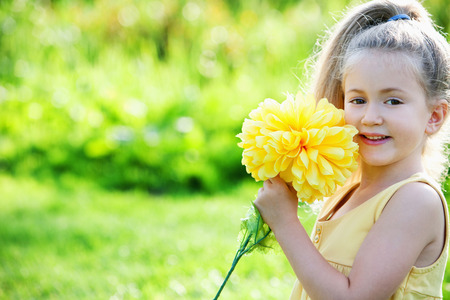 Girl holding a big yellow flowerの写真素材