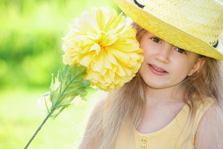 Girl holding a big yellow flowerの写真素材
