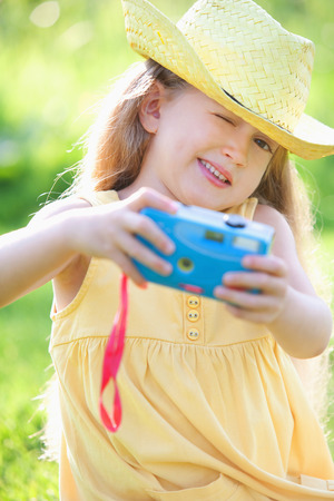 Girl taking a picture with a toy cameraの写真素材