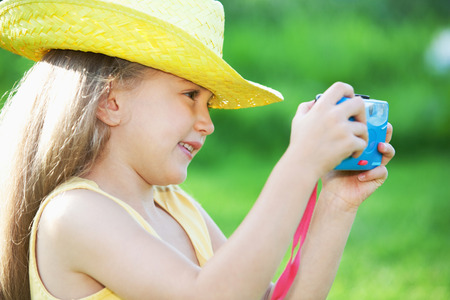 Girl taking a picture with a toy cameraの写真素材