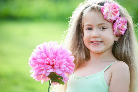 Girl holding a big pink flowerの写真素材