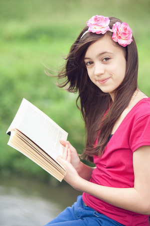 Girl reading a book outdoorsの写真素材