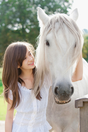 Girl petting horse outdoorsの写真素材