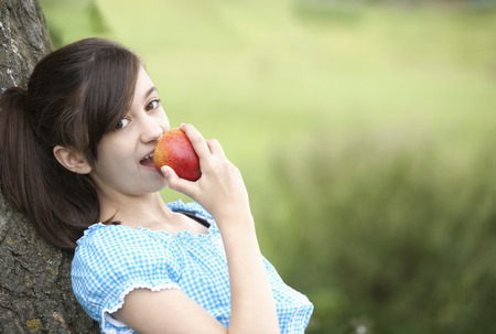 Girl eating an appleの写真素材