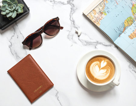 Coffee cup, sunglasses and map on white marble background.の素材