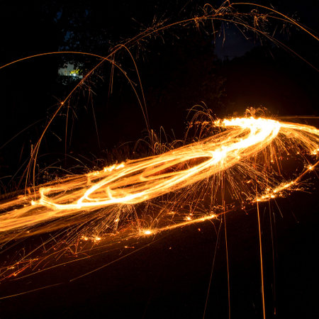 sparks from spinning steel wool at night, closeup of photoの素材
