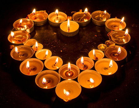 Candles in the shape of a heart on a dark background.の素材