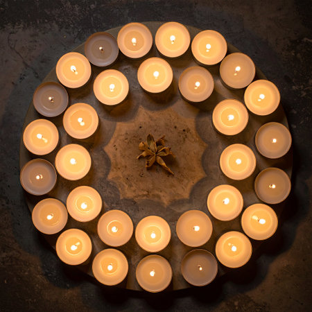 Burning candles in the shape of a circle on a dark backgroundの素材