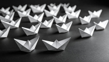 Leadership concept with paper boats on black background. Copy space.の素材