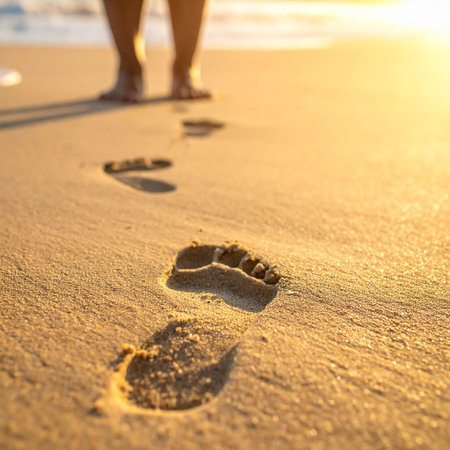 Footprints in the sand on the beach at sunset. Travel conceptの素材