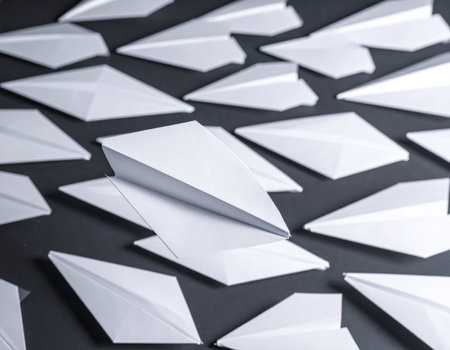White paper plane on a black background. Business concept for leadership and success.の素材