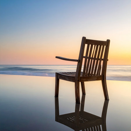 Wooden chair on the beach with reflection of the sea and sunsetの素材