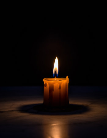 Burning candle on a black background. Shallow depth of field.の素材