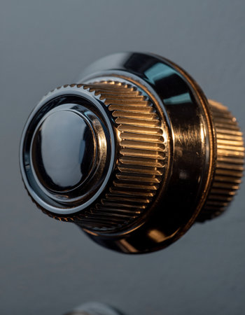 Close-up of an old metal door knob on a black backgroundの素材