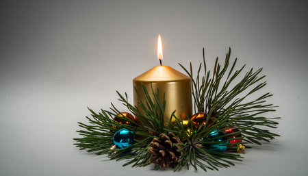 Christmas candle with pine branch and colorful baubles on white backgroundの素材