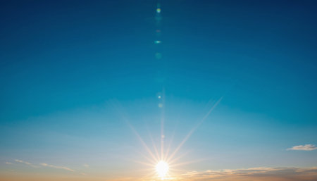 Sunset sky background. Blue sky with white clouds and sunbeams.の素材