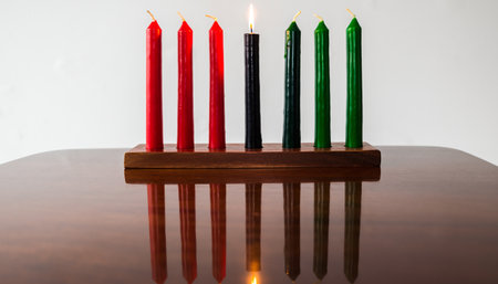 Candles on a table in a room with a white wall and reflectionの素材