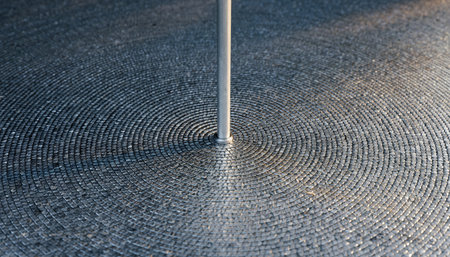 Close-up of a metal pole on a circular patterned surfaceの素材