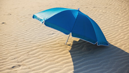 Blue beach umbrella on the sand. Summer vacation concept. Selective focusの素材