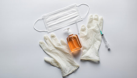 Coronavirus COVID-19 vaccine bottle, medical gloves and syringe on white background.の素材