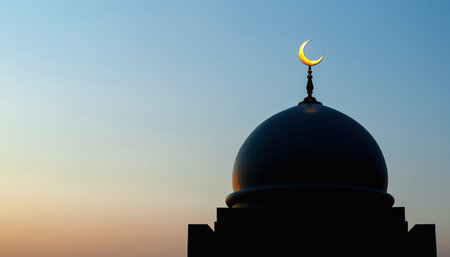 Silhouette of mosque dome with crescent moon at sunset.の素材