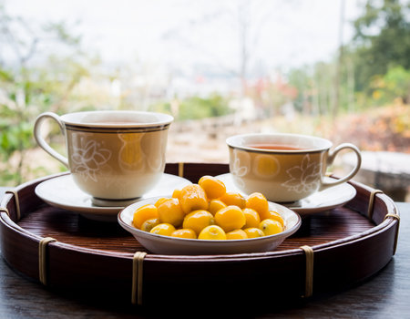 Cup of tea with orange fruit on wooden tray, stock photoの素材