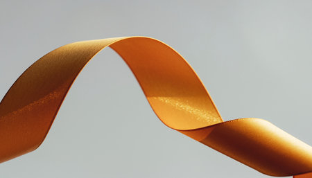 Curled orange ribbon on a gray background. Horizontal photo.の素材