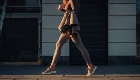 Fashionable young woman in a beige coat on the street.の素材